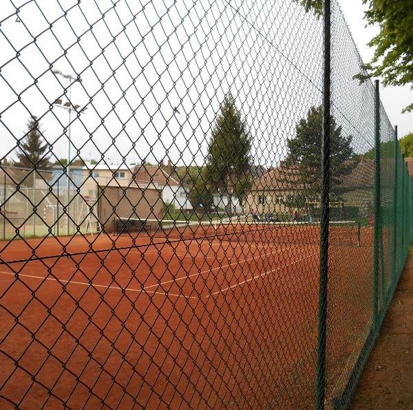 Linie tenisového oplocení ze zeleného čtyřhranného pletiva na sportoviště