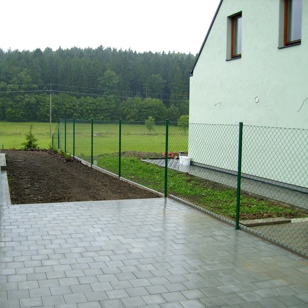 Jednoduchý a levný zelený plot kolem domu vytvořený z poplastovaného pletiva Super